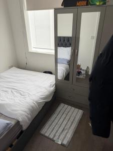 a small bedroom with a bed and a mirror at Holiday Haven in Potters Bar