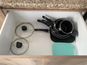a kitchen counter with a pot and pans in a drawer at Casa Tronos in San Isidro de los López +13 photos