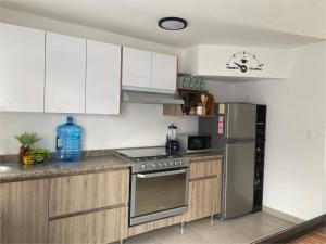 a kitchen with white cabinets and a stainless steel refrigerator at Casa Tronos in San Isidro de los López