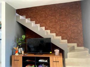 a living room with a tv and a brick wall at Casa Tronos in San Isidro de los López