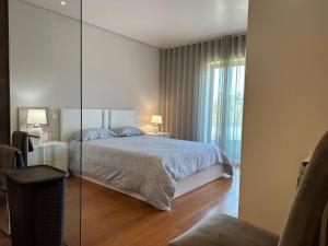 a bedroom with a bed and a glass wall at Ofir Beach Apartment in Fão +61 photos