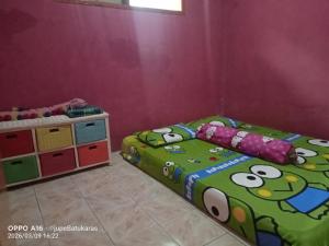 a childs bedroom with a bed and a cabinet at Jupe Homestay batukaras in Batukaras