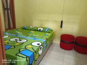 a bedroom with a bed and two stools at Jupe Homestay batukaras in Batukaras