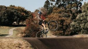a man doing a trick on a bike on a road at Omeo Holiday Park in Omeo +22 photos