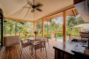 a screened in porch with a table and chairs at Evia Life Resort in Puerto Viejo