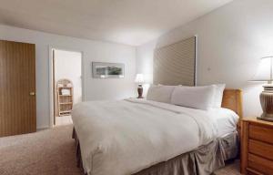 Enzian - CoralTree Residence Collection في فيل: غرفة نوم بها سرير أبيض كبير ونافذة