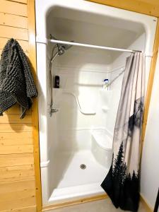 a shower in a bathroom with a shower curtain at Caribou Cottage in Churchill +7 photos