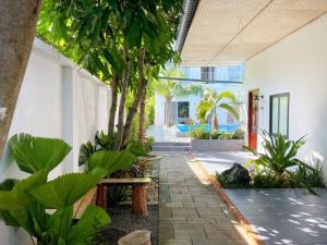 a courtyard of a house with a bench and trees at Inner Peace Homestay Phan Thiet in Phan Thiet
