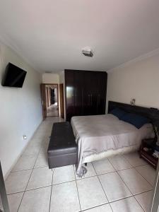 a bedroom with a bed and a black leather seat at Moto GP sobrado in Goiânia