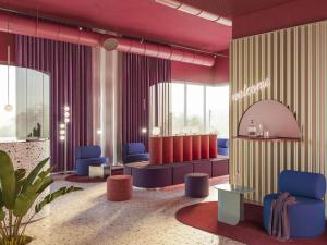 a salon with blue chairs and a waiting room at ibis Styles Muenchen Perlach in Munich