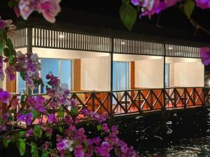 a building with windows with purple flowers in front of it at BIHING ANGAN water chalets in Semporna