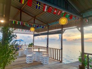 a gazebo with a table and chairs and the ocean at BIHING ANGAN water chalets in Semporna