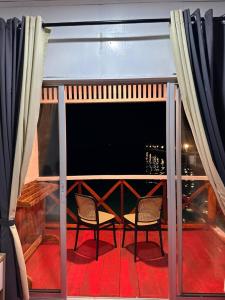 a balcony with two chairs and a view of the city at BIHING ANGAN water chalets in Semporna