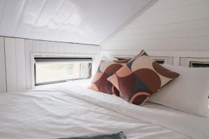 a white bed in a room with a window at Sweet Hart 1 by Tiny Away in Tamahere