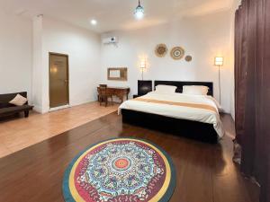 a bedroom with a bed and a rug on the floor at Natasya Kuta Beach Hotel in Kuta