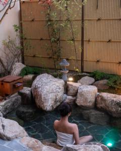 a woman sitting on a rock in a pool of water at Goyuhanga in Busan