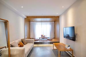 a living room with a couch and a tv at Sanfuyizhai Homestay in Taizhou