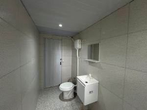 a bathroom with a toilet and a phone on the wall at Quarto Boto Tucuxi in Santarém +55 photos