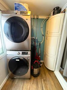 a microwave and a washing machine in a room at Beluga Beach House in Churchill