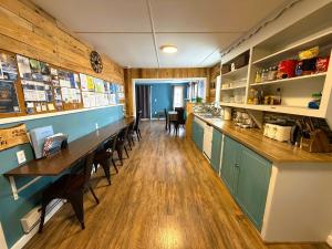 a restaurant with a long counter and tables and chairs at Beluga Beach House in Churchill