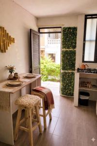 a kitchen with a counter and a table and stool at BORA - Apto 101Tu espacio fuera de casa in Ibagué