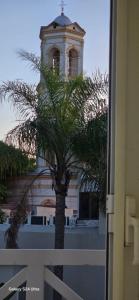 a palm tree in front of a building with a clock tower at Casa Azul in San Pedro