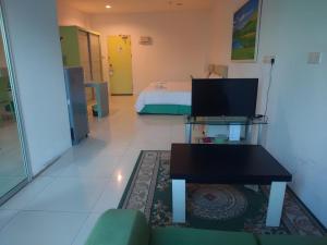 a room with a bed and a couch and a table at Santorini Hotel in Miri