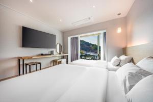 a hotel room with two beds and a television at Incheon The Rest Hotel in Incheon +45 photos