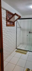 a bathroom with a shower with a glass wall at Casa Irmã Lua in Porto Seguro +18 photos