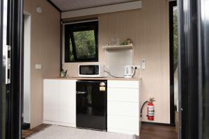 a kitchen with a black refrigerator and a microwave at Sweet Hart 2 by Tiny Away in Tamahere
