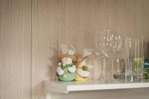 a shelf with two wine glasses and figurines on it at Sweet Hart 2 by Tiny Away in Tamahere