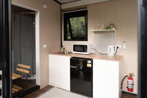 a small kitchen with a microwave and a sink at Sweet Hart 2 by Tiny Away in Tamahere +16 photos