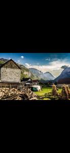 a building in a field with mountains in the background at Highland guest house Vuthaj in Vusanje +14 photos