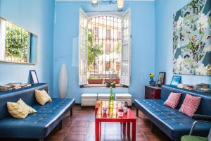 a blue room with blue couches and a table at Onefam Centro in Seville +22 photos