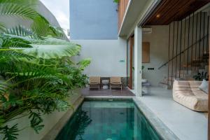 a swimming pool in the middle of a house at Unwind Villa by Betterplace in Canggu