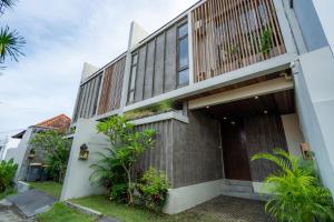 an external view of a building with plants at Unwind Villa by Betterplace in Canggu +38 photos