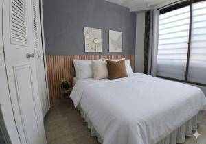 a bedroom with a large bed with white sheets and pillows at Tu Espacio en Ibague in Ibagué +9 photos