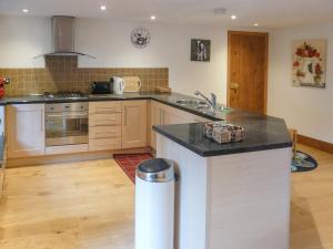a kitchen with a island in the middle of it at Hollin Bank Cottage in Salterforth