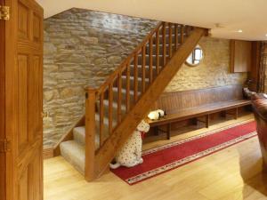 a stuffed animal is standing under a staircase in a room at Hollin Bank Cottage in Salterforth