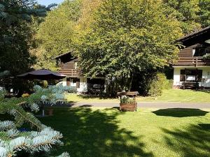 a yard with a bench and an umbrella in front of a house at Feriendorf Reinskopf in der Eifel in Schönecken