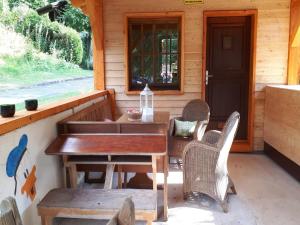 a table and chairs on the porch of a cabin at Feriendorf Reinskopf in der Eifel in Schönecken