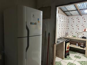 a white refrigerator in a kitchen with a window at Quarto Sairé in Santarém