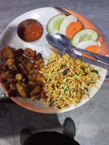 a plate of food with meat and rice and vegetables at Hotel Diyalo in Trisūli Bāzār