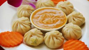 a plate of dumplings with a bowl of dipping sauce at Hotel Diyalo in Trisūli Bāzār