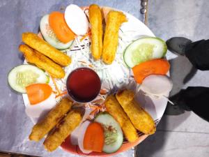 a plate of food with vegetables and fruit on it at Hotel Diyalo in Trisūli Bāzār