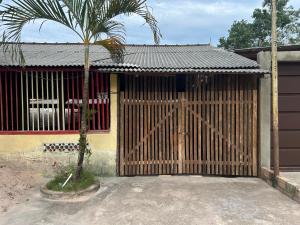 a wooden gate with a palm tree in front of a building at Quarto Sairé in Santarém