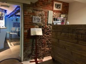 a room with a brick wall and a sign on a pole at The Wheatsheaf in Salisbury