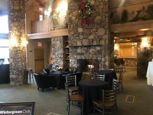 a restaurant with tables and chairs and a fireplace at Private Mountain Condo in Wintergreen