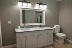 a bathroom with a sink and a toilet and a mirror at Spacious 3 bedroom duplex home inside Worcester in Worcester