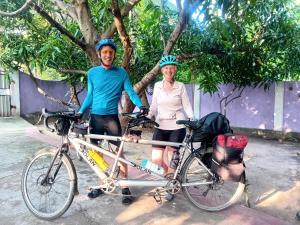 a man and a woman standing next to a bike at Enoch Guest House in Mannar